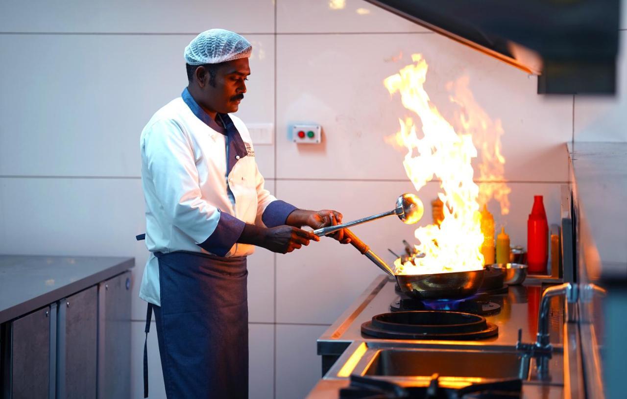 慕那尔大象通道度假村 蒙纳 外观 照片 A chef cooking with a blowtorch